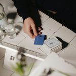 A hand is holding a blue card.